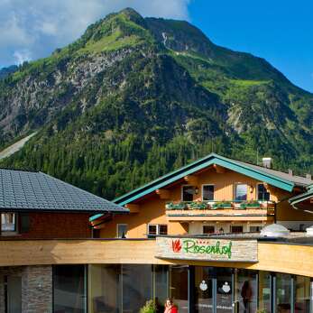 Das Familienhotel Rosenhof liegt mitten im Kleinwalsertal mit Blick auf die Berge.